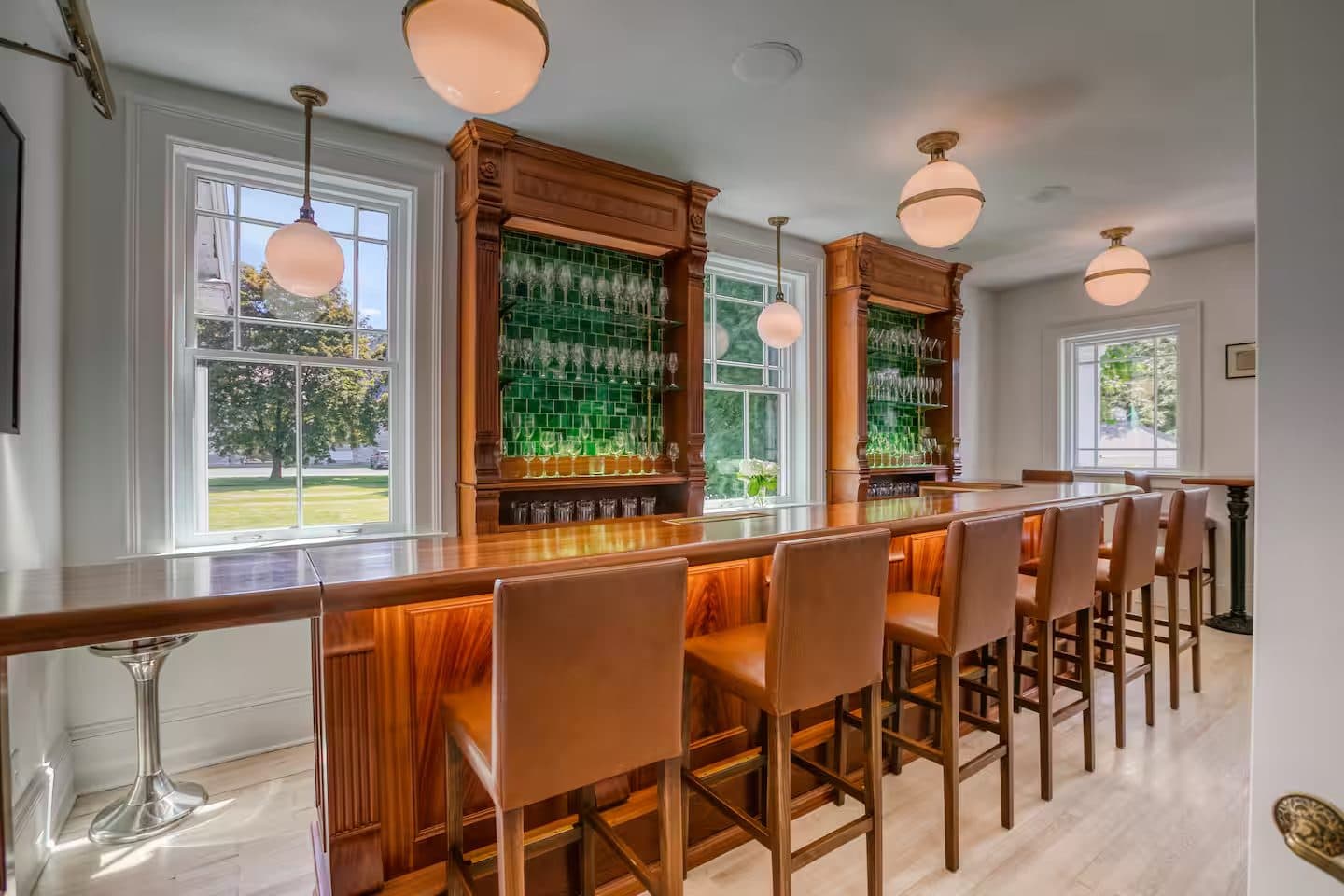 The wood-panelled bar with backlit shelving and leather stools