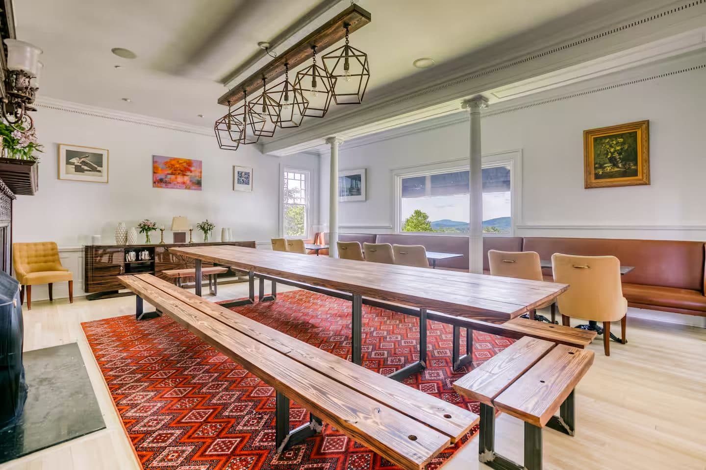 The farmhouse dining hall with a long live-edge table beneath valley views
